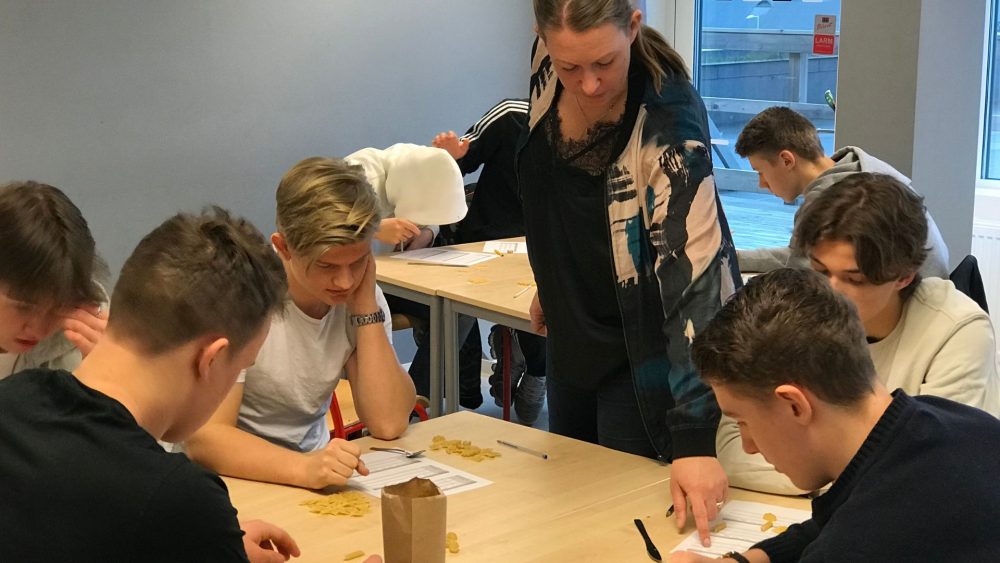 En grupp elever på Aspero gymnasieskola får hjälp av läraren Lisa